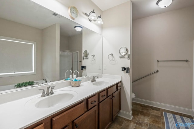 117 Somerset Park Dr NE, Huntsville, AL 35811 - bathroom featuring double vanity, baseboards, toilet, and a shower with door