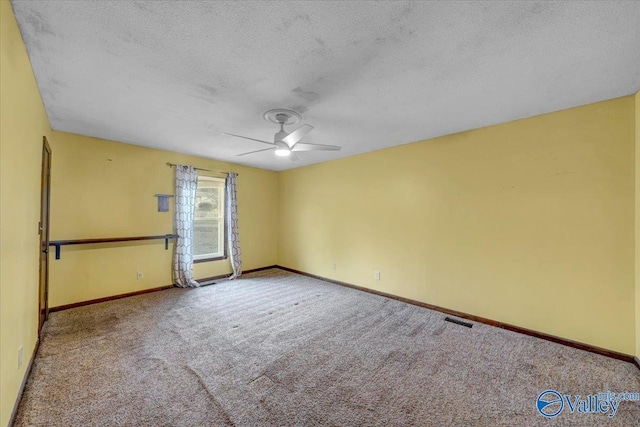 spare room featuring ceiling fan, light colored carpet, and a textured ceiling