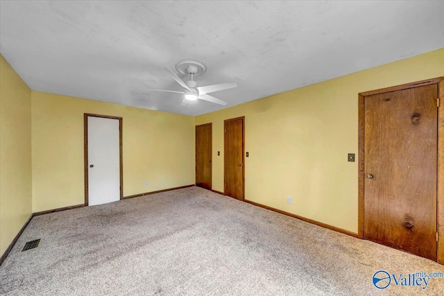 carpeted spare room featuring ceiling fan