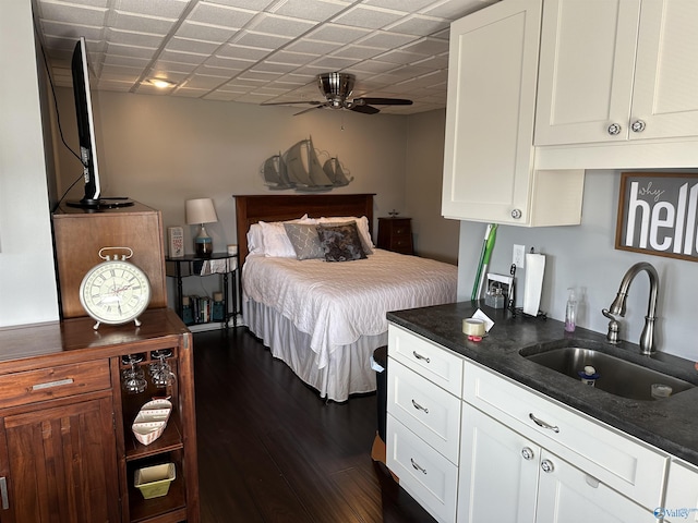 bedroom featuring ceiling fan, sink, and dark hardwood / wood-style flooring