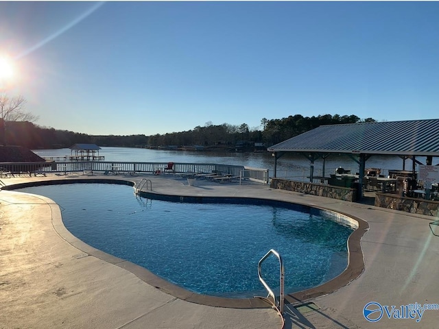 view of swimming pool featuring a gazebo, a water view, and a patio area