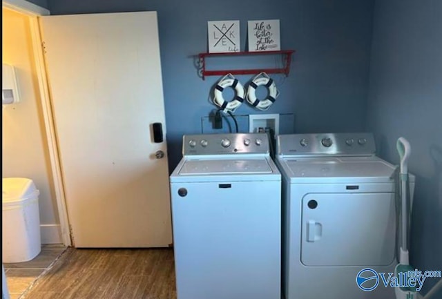 laundry area featuring hardwood / wood-style flooring and washing machine and clothes dryer