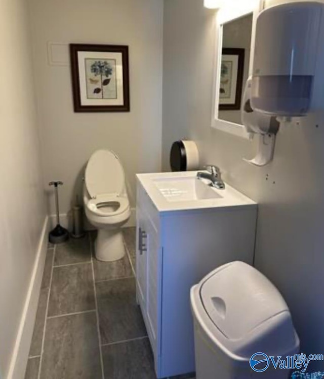 bathroom featuring water heater, vanity, tile patterned flooring, and toilet