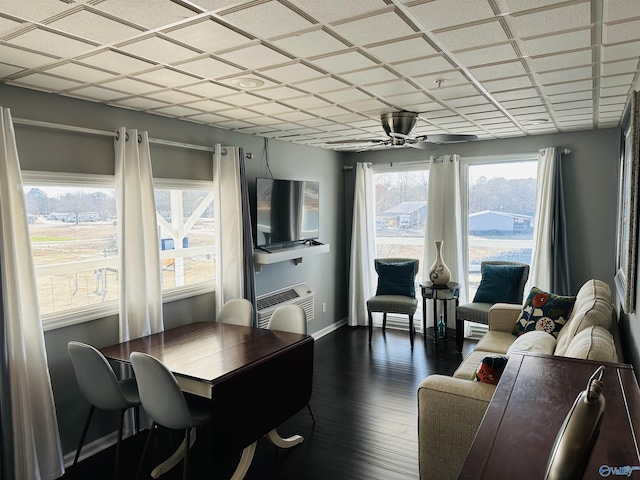 dining room with dark wood-type flooring, ceiling fan, plenty of natural light, and a wall unit AC