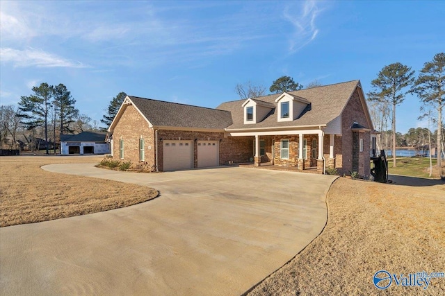 cape cod house with a garage, covered porch, and a front lawn