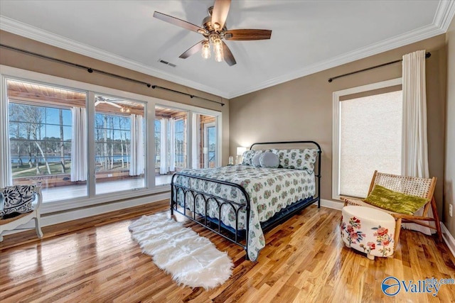 bedroom with ceiling fan, hardwood / wood-style flooring, and ornamental molding