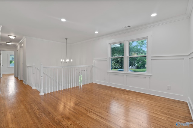 3631 NW Stag Run Dr, Huntsville, AL 35810 - unfurnished room featuring a decorative wall, a chandelier, crown molding, wood finished floors, and wainscoting