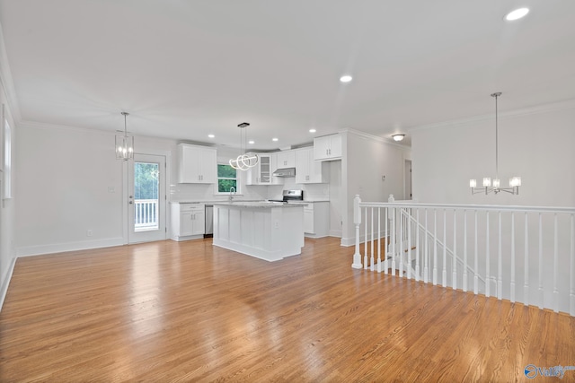 3631 NW Stag Run Dr, Huntsville, AL 35810 - kitchen featuring a chandelier, white cabinets, under cabinet range hood, stainless steel appliances, and ornamental molding