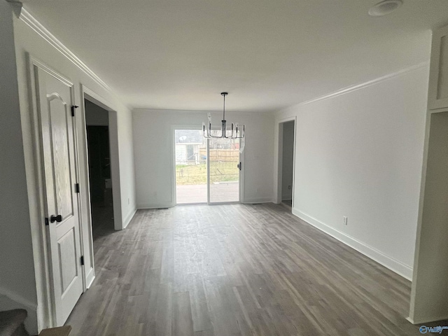 unfurnished dining area featuring ornamental molding, dark wood-type flooring, an inviting chandelier, and baseboards