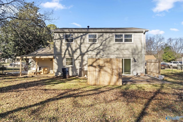 rear view of house with a lawn, a patio area, and central air condition unit