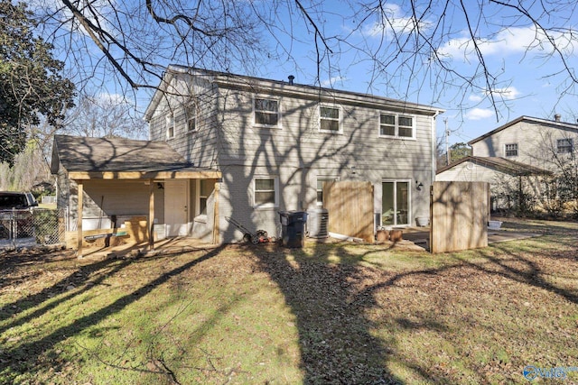 rear view of property featuring a lawn