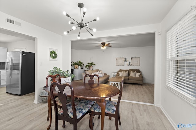 dining area featuring ceiling fan with notable chandelier and light hardwood / wood-style floors