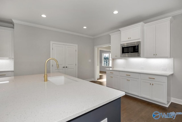 66 Natures Ridge Way, Huntsville, AL 35803 - kitchen featuring stainless steel microwave, light stone countertops, decorative backsplash, white cabinetry, and ornamental molding