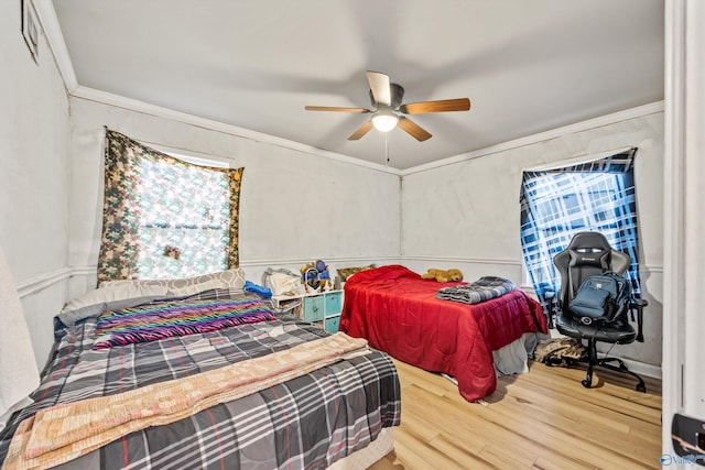 bedroom with hardwood / wood-style flooring, ceiling fan, and crown molding