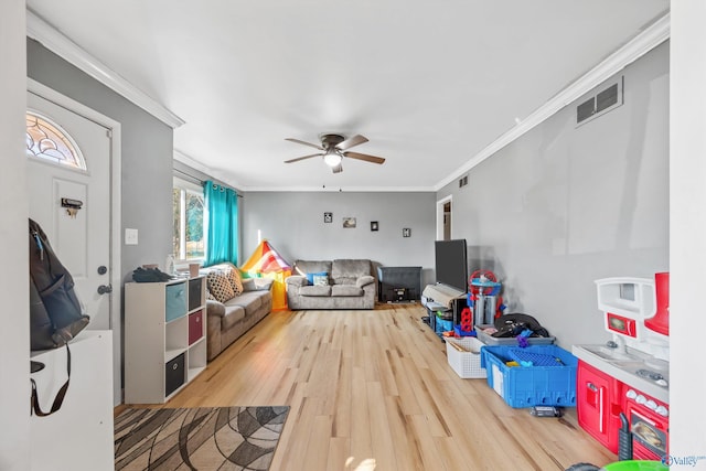 game room with crown molding, light hardwood / wood-style flooring, and ceiling fan