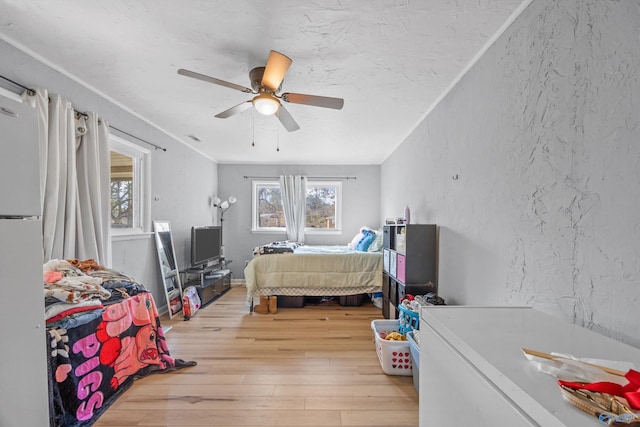 bedroom featuring white fridge, ceiling fan, and light hardwood / wood-style floors