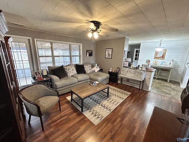 living area with dark wood-style flooring, ceiling fan, and visible vents