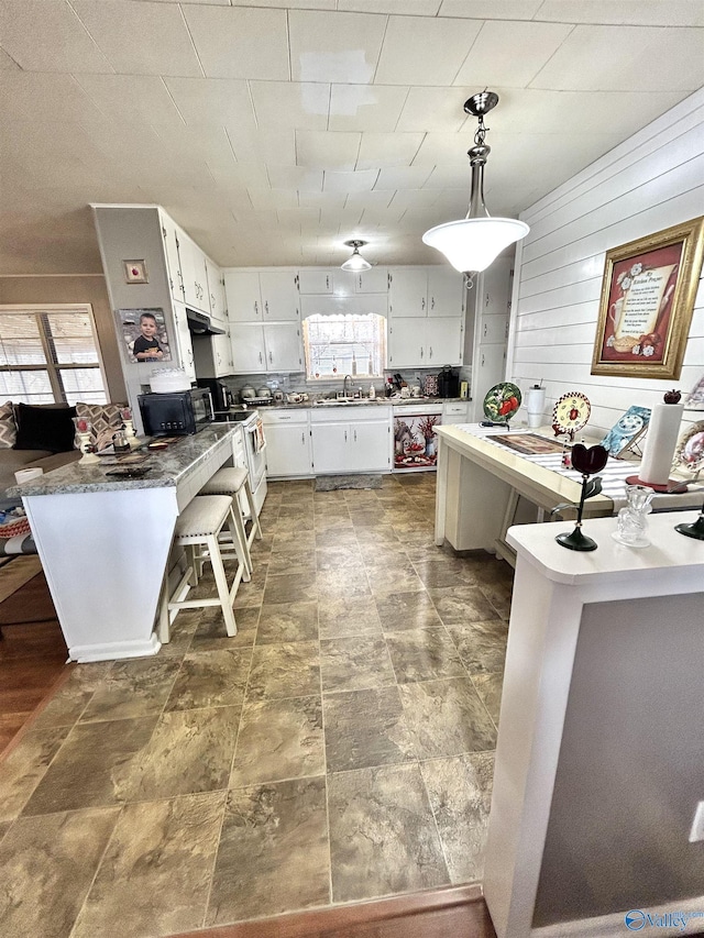 kitchen with a wealth of natural light, white cabinets, a sink, and white electric range oven
