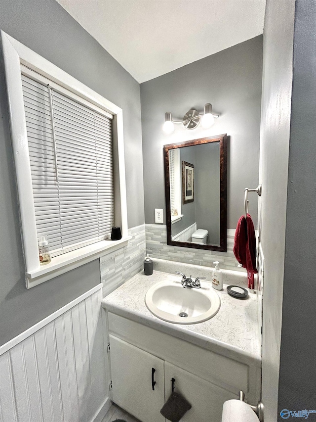 bathroom with vanity and a wainscoted wall