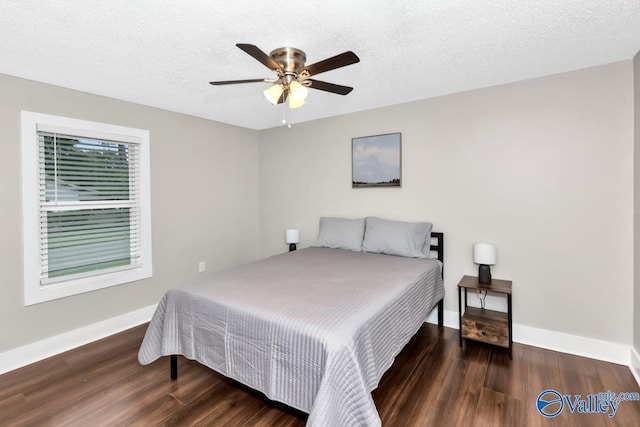 bedroom with ceiling fan, baseboards, wood finished floors, and a textured ceiling