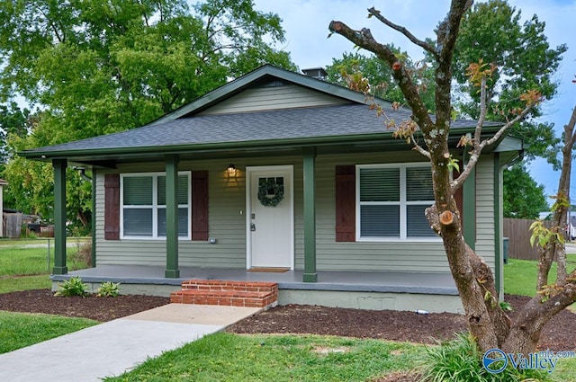 bungalow-style house featuring fence, a shingled roof, and covered porch