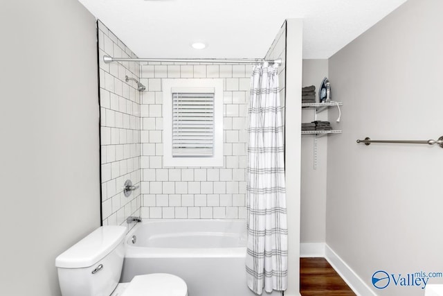 full bath with wood finished floors, shower / tub combo, toilet, and baseboards