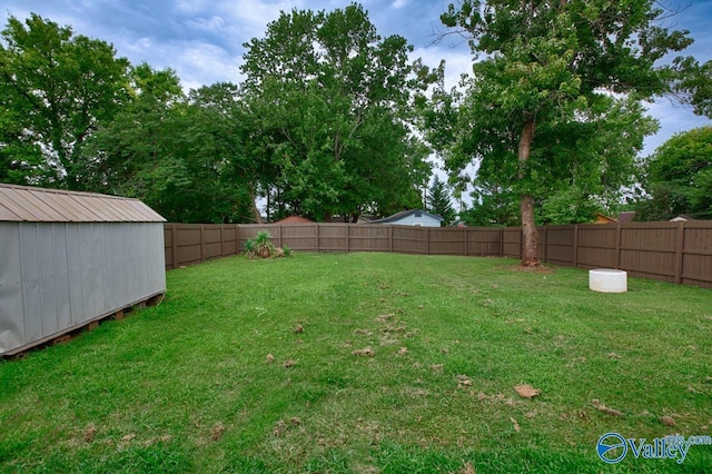 view of yard featuring a fenced backyard, an outdoor structure, and a storage shed