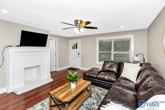 living room with dark wood finished floors, baseboards, recessed lighting, ceiling fan, and a fireplace