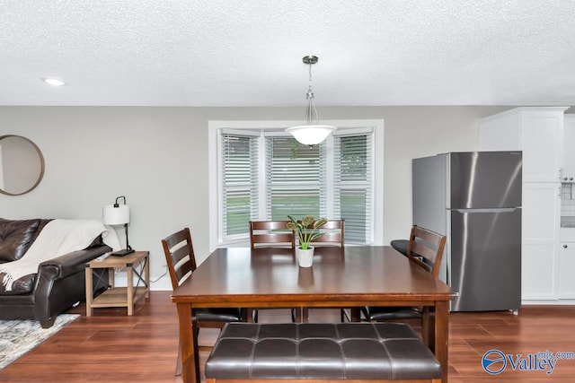 dining space featuring dark wood-type flooring, a textured ceiling, and recessed lighting