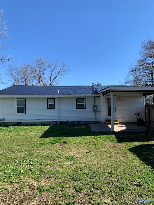 rear view of house with a lawn and a patio area