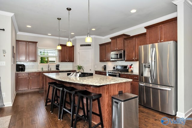 kitchen featuring a breakfast bar area, tasteful backsplash, a center island, pendant lighting, and stainless steel appliances