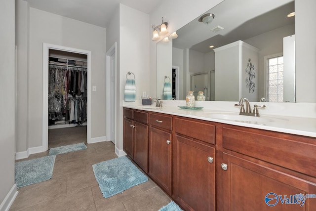 bathroom featuring tile patterned flooring, vanity, and walk in shower