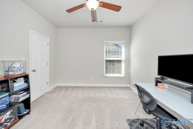 carpeted office space featuring ceiling fan