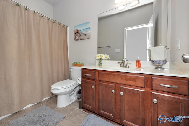 bathroom with tile patterned flooring, vanity, and toilet