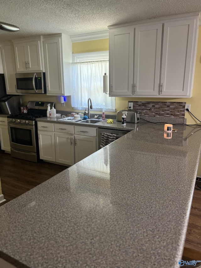 2143 Meadowood Dr, Southside, AL 35907 - kitchen featuring appliances with stainless steel finishes, dark wood finished floors, a sink, a textured ceiling, and white cabinets