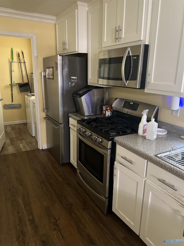 2143 Meadowood Dr, Southside, AL 35907 - kitchen with appliances with stainless steel finishes, independent washer and dryer, white cabinetry, dark wood-style floors, and ornamental molding