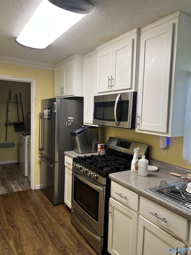 2143 Meadowood Dr, Southside, AL 35907 - kitchen with appliances with stainless steel finishes, washer and dryer, dark wood finished floors, white cabinetry, and a textured ceiling