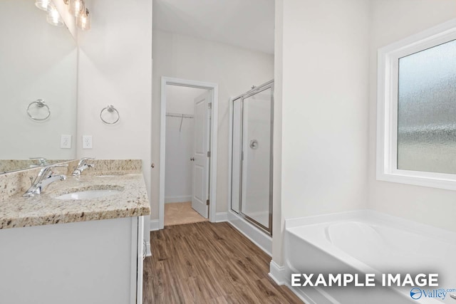 bathroom with separate shower and tub, vanity, and wood-type flooring