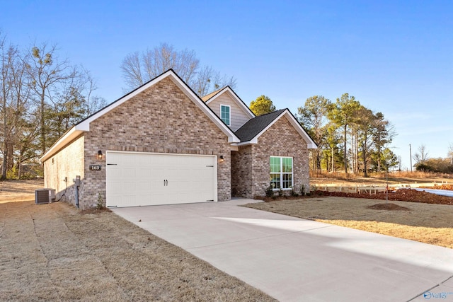 view of front facade featuring driveway, a garage, central AC, and brick siding