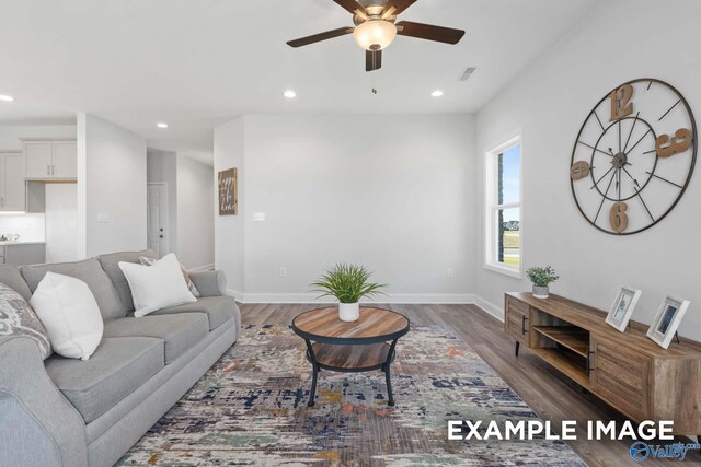 living room featuring ceiling fan and dark wood-type flooring