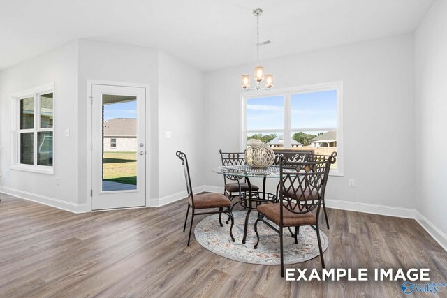 dining space with a chandelier and wood-type flooring