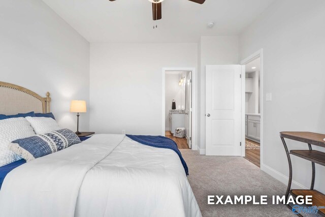 carpeted bedroom with ensuite bath and ceiling fan