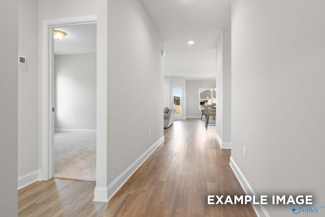 hallway with hardwood / wood-style flooring