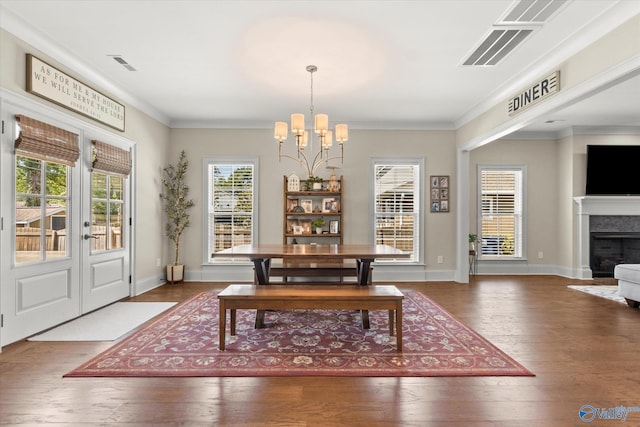 dining room with a notable chandelier, crown molding, and dark wood-type flooring