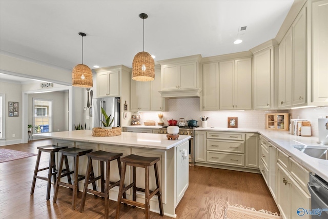 kitchen featuring a kitchen breakfast bar, a center island, premium appliances, and dark wood-type flooring