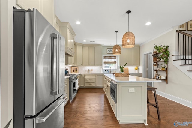 kitchen with a kitchen breakfast bar, high end appliances, dark hardwood / wood-style floors, a kitchen island, and hanging light fixtures