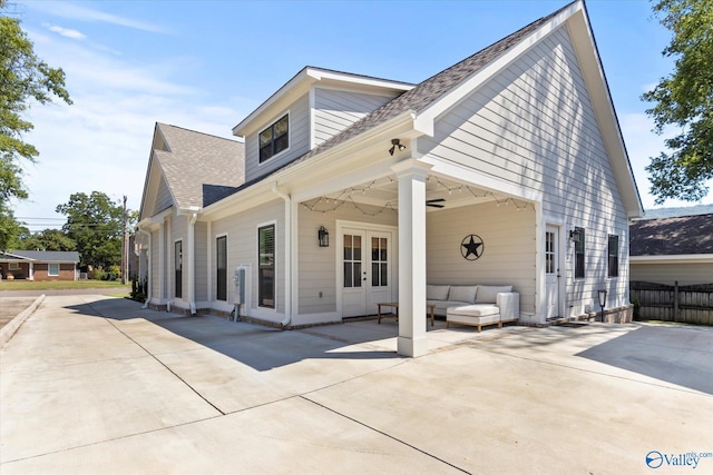 view of front facade featuring french doors, an outdoor living space, and a patio area