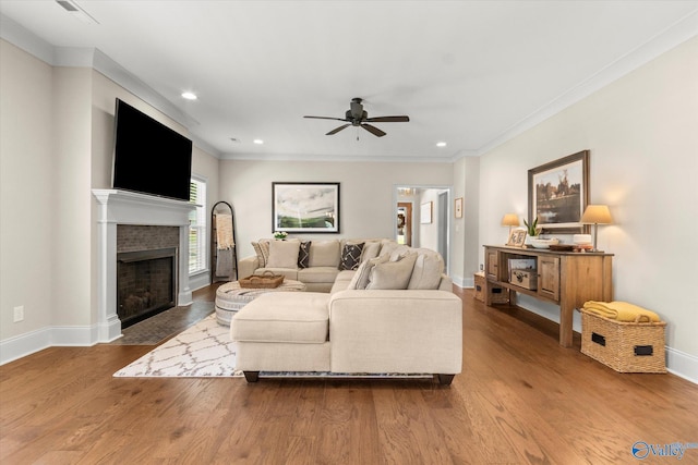 living room featuring hardwood / wood-style flooring, ceiling fan, and ornamental molding