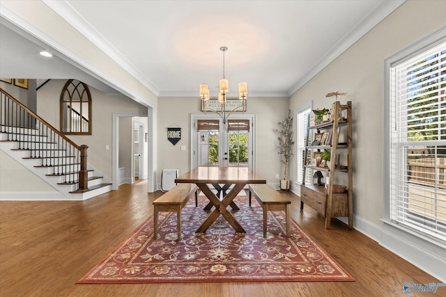 dining area with ornamental molding, a healthy amount of sunlight, and hardwood / wood-style floors