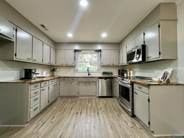 kitchen with light wood-style floors, visible vents, recessed lighting, a sink, and stainless steel appliances